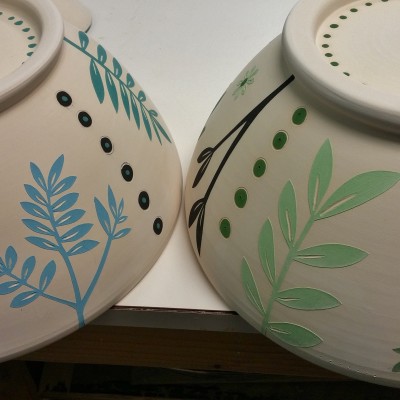 2 ceramic bowls with abstracted plant designs at rest in the studio